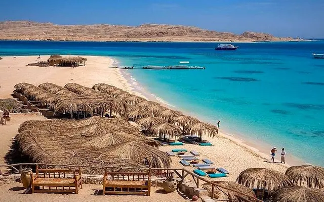 Palm-leaf umbrellas and loungers on the beach at Mahmya, Giftun Island