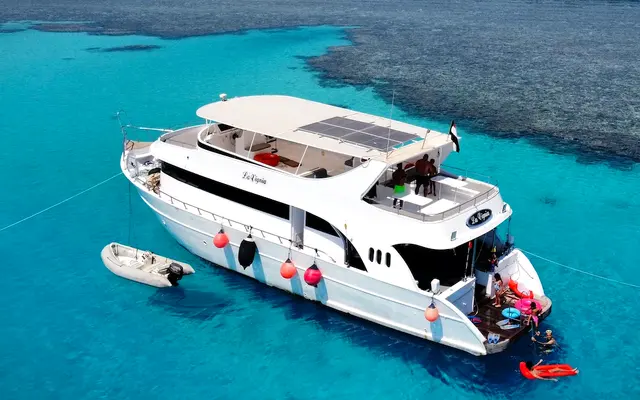 Private yacht anchored over a coral reef near Hurghada with guests swimming